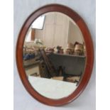 A Victorian oval bevelled edged mirror with an ebony and boxwood inlaid mahogany frame; 69cm oval.