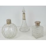 Three HM silver and cut glass perfume bottles;