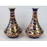 A pair of Wilton ware blue ground vases with gilt decoration; 22cm high; chip to the base of one.