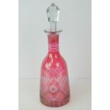 A cranberry glass decanter with stopper, 33cm high.