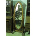 A contemporary oval cheval type mirror raised over turned base, all standing 175cm high.