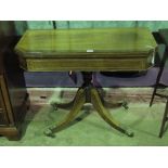 A late 19th century mahogany fold-over games table with green baize interior raised over quatroform