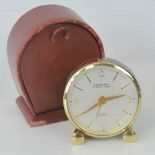 A looping Swiss made miniature eight day travel timepiece in original leather case.