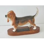 A Beswick Connoisseur figure of a Basset Hound, stood upon wooden plinth, 20cm long.