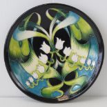 A Moorcroft plate with green glade design by Nicola Slaney, 16cm dia.