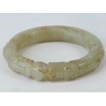 A Chinese carved celadon jade bangle wit
