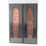 A pair of large framed masks, 100 x 35cm