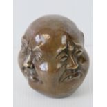 An Oriental bronzed paperweight - four faces of Buddha, 8.5cm high.