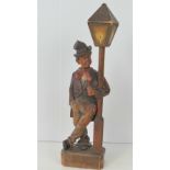 A Black Forest type clockwork novelty automaton figurine, whistling man leaning against lamppost,