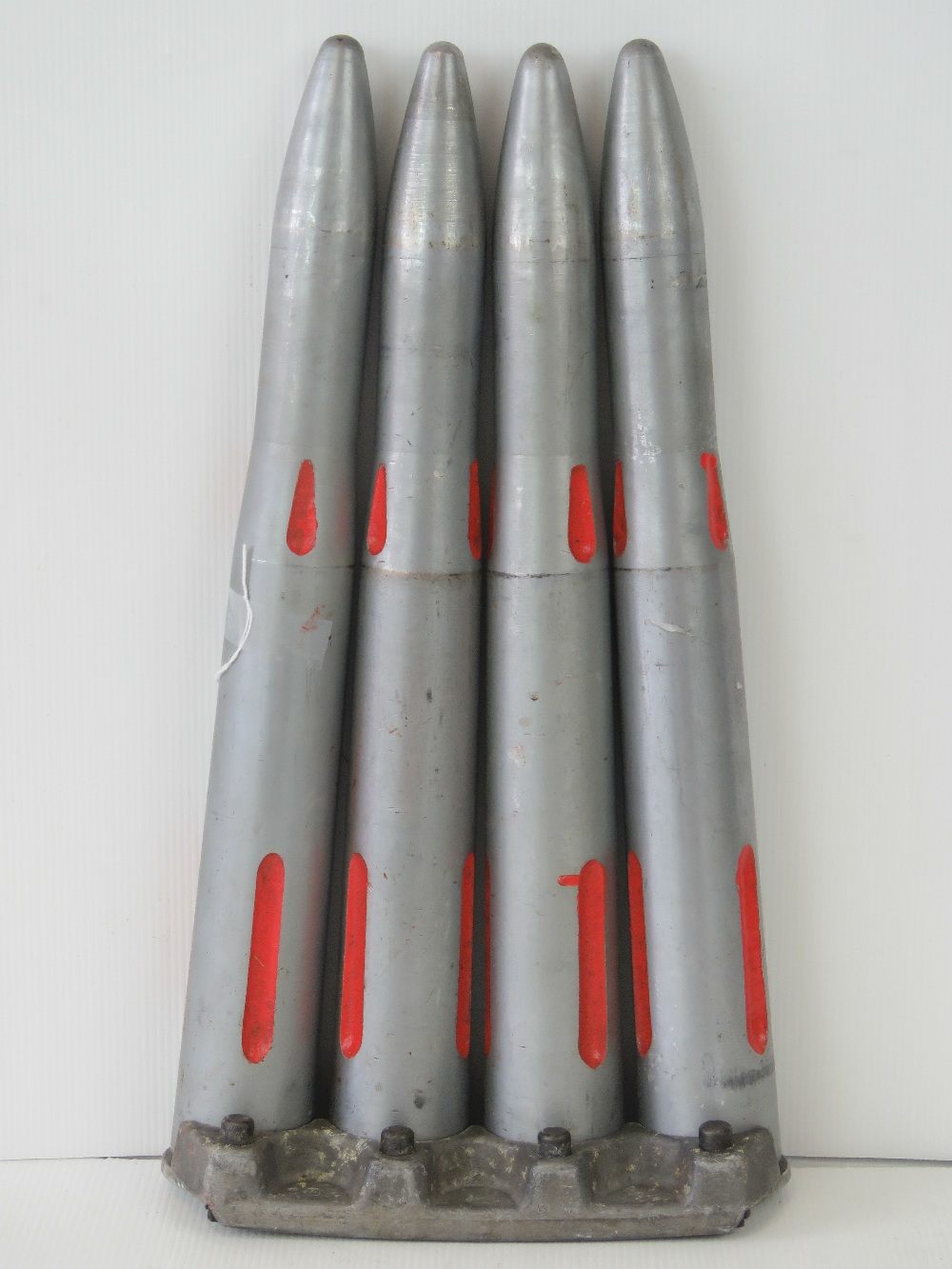 Four inert 40 mm drill rounds on clip, length approx 45 cm.