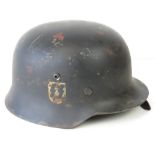 A WWII German helmet, later painted and applied SS double decal, leather lining and chin strap.