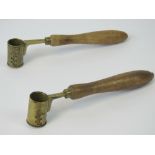 Two French adjustable brass measuring cups with turned wooden handles,