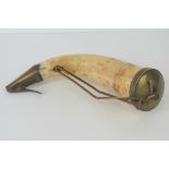 A late 18th century powder horn, screw filling cap to one end, sprung conical release cap opposing,