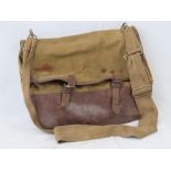 A WWII canvas and leather dispatch bag containing four rolls of webbing within.