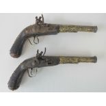 A pair of 18th century flintlock pistols of naive form, working mechanisms,