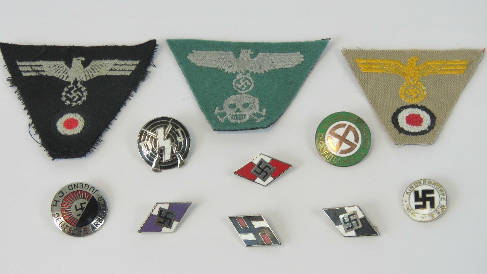 A quantity of reproduction WWII cloth and metal badges. 11 in total.