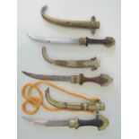 Three souvenir Jambiya daggers each with brass curved scabbard, wooden grip and brass pommel.