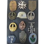 An assorted selection of reproduction WWII German badges. Ten metal badges and two cloth badges.