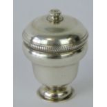 A late 18th/early 19th century white metal nutmeg grater in the form of an urn,