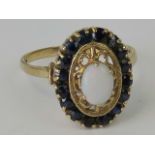 A 9ct gold opal and sapphire ring, centr