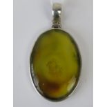 A large oval translucent yellow agate pe