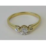 A 9ct gold solitaire ring, illusion set diamond with further diamond to each shoulder, approx 0.