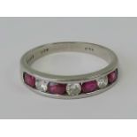 A platinum, diamond and ruby half eternity ring, seven alternating round cut channel set stones,