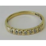 A 9ct gold and diamond band, carved head set with seven diamonds, hallmarked 375, size Q, 1.7g.