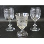 A pair of wine glasses raised on knopped stems and having engraved ribbon and flower decoration to