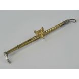 A 9ct gold stock pin or brooch depicting a foxes head upon a bar styled as a riding crop with white