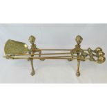 A three-piece brass 'eagles foot' fireside companion set comprising; poker,