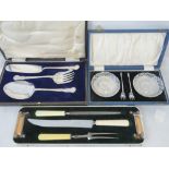 A vintage five piece carving set including knife, fork, sharpener and knife rests,