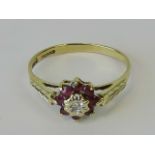 A 9ct gold diamond and ruby cluster ring, central diamond in star setting surrounded by a gallery