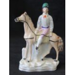 A Staffordshire figure depicting Fred Archer mounted on a race horse c1860's, height 20cm.