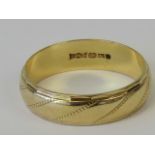 A 9ct gold band with engraved diagonal strip pattern, hallmarked 375, size O, 2.