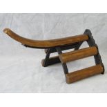 A horse saddle wall hanger with cast iron and wooden slats; 39cm long.