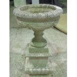 A 20th century pre cast Haddon stone type garden urn, on square shaped and stepped base, 60cm dia,