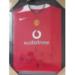 A framed and as new Manchester United Vodaphone players shirt bearing eleven players signatures