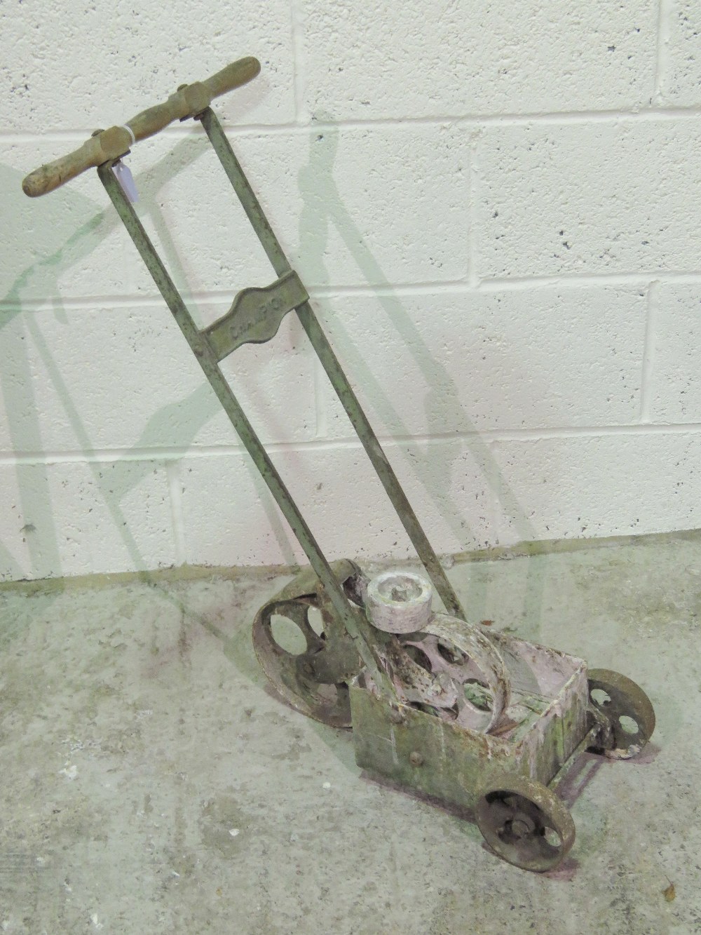 A vintage Champion tennis court painting machine, wooden handle and cast wheels.