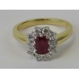 An 18ct gold diamond and ruby ring, central emerald cut ruby 0.