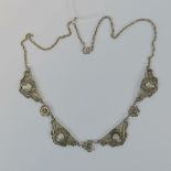 A silver filigree necklace, four panels each with inset shell cameo and separated by floral panels,