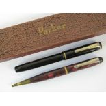 A Burnham black cased fountain pen with 14ct gold nib and a Burnham red marbled propelling pencil,