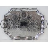 A large twin handled tray of octagonal scalloped form with engraved floral decoration, 57.5cm wide.