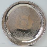 A large circular silver plated tray with repoussé and engraved floral decoration, 43cm dia.