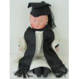 A doll in the form of an Oxbridge graduate having papier mache hand painted head and cloth limbs,