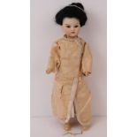 A bisque head Oriental doll by Simon & Halbig with brown glass eyes and open mouth showing teeth,