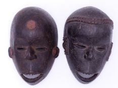 TWO AFRICAN CARVED WOOD MASKS WITH COPPER TEETH, YORUBA, NIGERIA . (2)