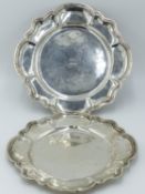 A PAIR OF WHITE METAL SALVERS, EACH WITH SHAPED RIM AND MOULDED BODER AND EACH ENGRAVED WITH ROMAN