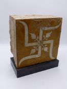 A LARGE INDO PERSIAN POTTERY AND MARBLE BLOCK TILE WITH HINDU / BUDDHIST SWASTICA INLAID DECORATION.