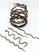 AN AFRICAN IRON ENTWINED SNAKE "CURRENCY" OBJECT AND FOUR FURTHER INDIVIDUAL IRON SNAKES, LOBI